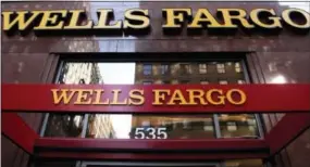  ?? THE ASSOCIATED PRESS ?? A Wells Fargo sign is displayed at a branch in New York. Wells Fargo is in the spotlight after its employees allegedly created up to 2 million bank and credit card accounts, transferre­d customers’ money without telling them and even created fake email...