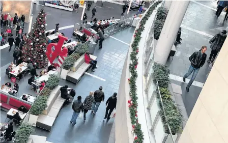  ?? JONATHAN ERNST/REUTERS ?? Shoppers make their way through Fashion Centre at Pentagon City, decorated for the holidays, in Arlington, Va, Monday.