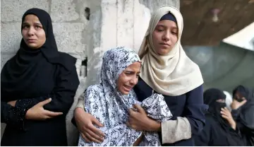  ??  ?? Relatives of Palestinia­n Sadi Muamar, who was killed by Israeli troops during a protest at the Israel-Gaza border, mourn during his funeral in the southern Gaza Strip. — Reuters photo