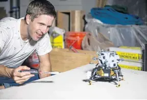  ?? PATRICK CONNOLLY/ORLANDO SENTINEL ?? Jonathan Duggins,who builds Legos and makes space dioramas, works on crafting a scene using a Lego Apollo 11 Lunar Module for his series, “Let’s Build Space,” on July 5 at his Orlando home.