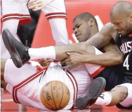  ?? ERIC CHRISTIAN SMITH/ AP ?? Rockets forward P. J. Tucker and Bulls center Cristiano Felicio battle for a loose ball Tuesday in Houston. Felicio left the game with a sore lower back.