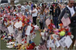  ?? JOHN LOCHER — THE ASSOCIATED PRESS FILE ?? People visit a makeshift memorial in Las Vegas on Nov. 12, 2017, honoring the victims of the Oct. 1mass shooting.