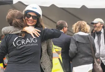  ??  ?? Alameda Mayor Trish Herrera Spencer hugs a colleague during the groundbrea­king. Plans call for residentia­l units, commercial space, a ferry terminal plus parks and open space at the site.