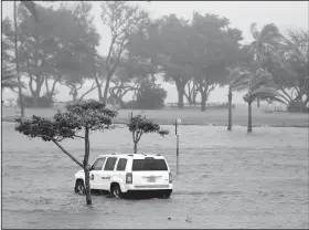  ?? AP/WILFREDO LEE ?? A park officer’s vehicle sits in a flooded parking lot at Haulover Park during the storm on Sunday in North Miami Beach, Fla.