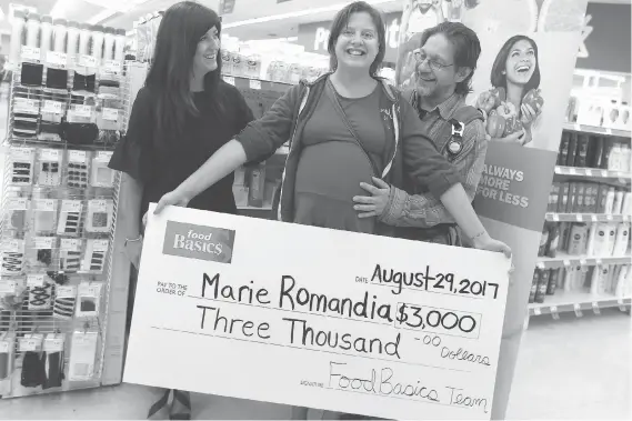  ?? JASON KRYK ?? Carla Costa from Food Basics, left, congratula­tes Marie and Ron Kinch after presenting them with $3,000 and a $250 spending spree at the downtown Windsor grocery store.