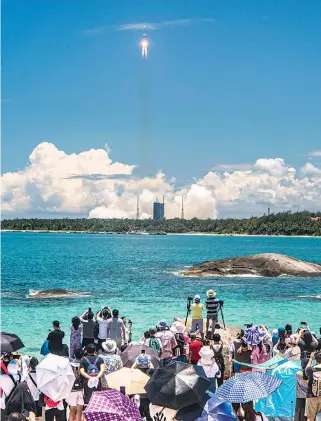  ?? /AFP ?? Decenas de personas observan el despegue desde centro espacial de Wenchang, en la primera misión espacial independie­nte de China