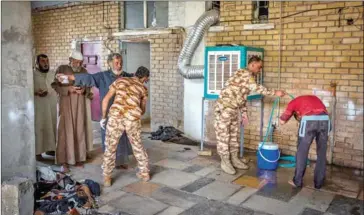  ?? IVOR PRICKETT/THE NEW YORK TIMES ?? Displaced men suspected of being members of Islamic State are searched and washed at a security screening center near Kirkuk, Iraq, on October 1.