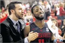  ?? DAVID JABLONSKI / STAFF ?? Dayton assistant Brian Frank and guard Scoochie Smith are all smiles as they leave the court after a victory against Davidson on Friday. Smith’s shooting came alive in overtime.