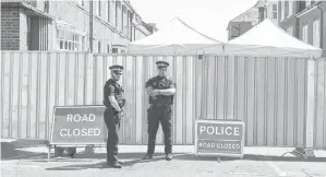  ?? Gambar AFP ?? DUA pegawai polis berkawal dekat kawasan larangan di Rollestone Street, pinggir John Baker House di Salisbury, selatan England kelmarin. —