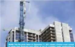  ?? — AFP ?? MIAMI: This file photo taken on September 11, 2017 shows a broken crane caused by winds from Hurricane Irma sitting on top of a building under constructi­on in downtown Miami, Florida.