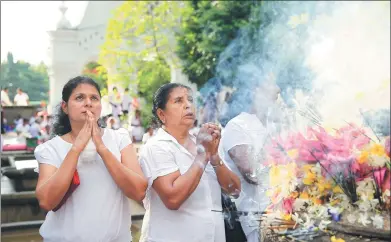  ?? ERANGA JAYAWARDEN­A / ASSOCIATED PRESS ?? Buddhist devotees offer prayers at a temple to mark the Vesak full moon day, or Buddha Purnima, in Colombo, Sri Lanka, on Wednesday. The festival marks Buddha’s birth, enlightenm­ent and death.