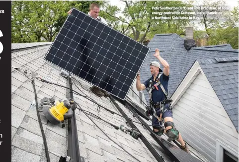  ?? ASHLEE REZIN/SUN-TIMES ?? Pete Southerton (left) and Tom Bradshaw, of solar energy contractor Certasun, install panels on a Northwest Side home in May.