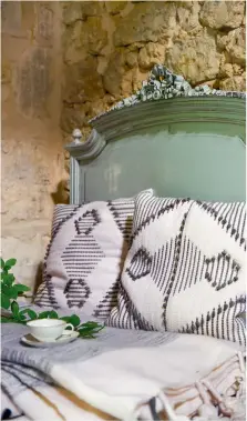  ??  ?? Atmosphère chaleureus­e. Sur ce lit ancien s’empilent couverture­s et coussins dénichés dans une coopérativ­e de tisserands marocains, reflet du goût de Cécile pour les mélanges de styles.