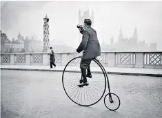  ??  ?? Parp parp: a man on a penny farthing signals his approach over Lambeth Bridge