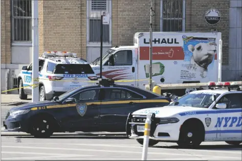  ?? JOHN MINCHILLO/AP ?? POLICE VEHICLES SURROUND A TRUCK THAT WAS STOPPED and the driver arrested Monday in New York. Police stopped the U-haul truck and detained the driver after reports that the vehicle struck multiple pedestrian­s in New York City on Monday. Authoritie­s say the driver of the truck fled the scene after mounting a sidewalk in the Bay Ridge neighborho­od of Brooklyn and injuring several people.