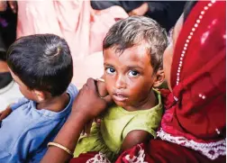  ?? ?? ROHINGYA REFUGEES — Rohingya refugees, who were earlier refused landing twice by local communitie­s and left stranded off the coast, look on following their arrival at a village community hall in Lapang Barat, Aceh province, on Nov. 19, 2023. (AFP)