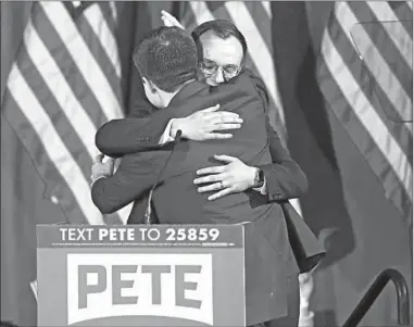  ?? MARY ALTAFFER/AP ?? Democratic presidenti­al candidate Pete Buttigieg embraces his husband, Chasten Buttigieg, at a primary night election rally in Nashua, New Hampshire, earlier this month.