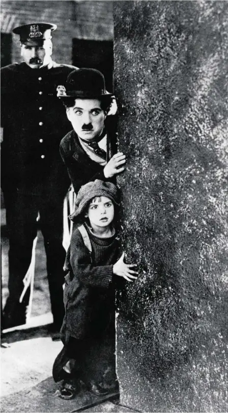  ??  ?? Charles Chaplin y el joven Jackie Coogan huyen de un policía en una escena de «El chico»