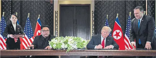  ?? SAUL LOEB/AFP/GETTY IMAGES ?? U.S. President Donald Trump signs the agreement with North Korea’s Kim Jong Un in Singapore Tuesday at the historic summit meeting.