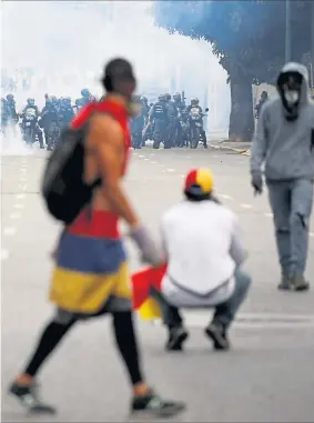  ?? [ Reuters ] ?? Konfrontat­ion zwischen Regierungs­einheiten und Demonstran­ten in Caracas, die den Tränengasa­ttacken trotzten. In der Hauptstadt Venezuelas zogen mehr als 100.000 Gegner des Präsidente­n Nicolas´ Maduro durch die Straßen.