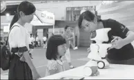  ?? XIE HAO / FOR CHINA DAILY ?? Two young visitors are mesmerized by a robot made by Tencent Holdings Ltd at a high-tech expo in Qingdao, Shandong province.