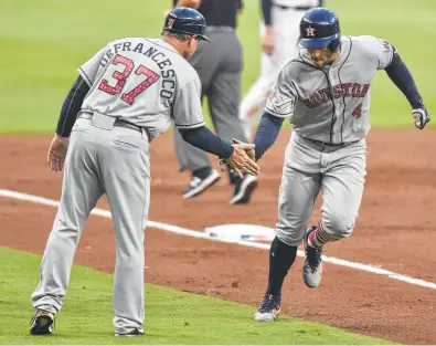  ?? Richard Hamm / Associated Press ?? Substitute third-base coach Tony DeFrancesc­o, left, was a busy man Tuesday night as the Astros racked up the runs, including a third-inning home run by George Springer for his 25th of the season.