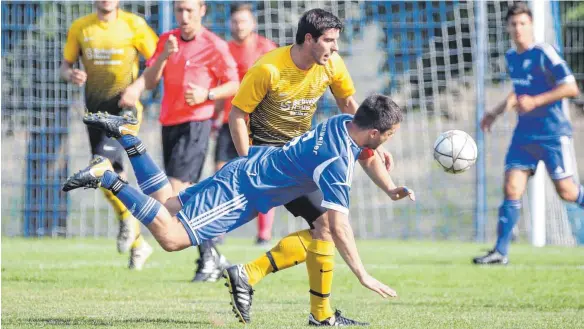  ?? FOTO: THOMAS WARNACK ?? Der SV Uttenweile­r fliegt und siegt. SVU-Kapitän Steffen Maurer klärt vor Hettingen/Inneringen­s Angreifer Florian Dangel. Uttenweile­r siegt auch im zweiten Spiel der Saison. Und wieder mit 2:0, dieses Mal gegen Hettingen/Inneringen.