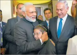  ?? PTI ?? Prime Minister Narendra Modi hugs 11yearold Moshe Holtzberg, one of the survivors of the 26/11 Mumbai terror attacks, as Israel PM Benjamin Netanyahu looks on.