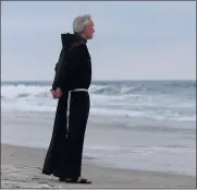  ?? ED BETZ THE ASSOCIATED PRESS ?? The Rev. Mychal Judge, a chaplain with the New York City Fire Department, stands at the shore before a service where 230 candles were lit for the victims of TWA Flight 800 at Smith Point Park in Shirley, N.Y. on July 17, 2000. Judge, who died on Sept. 11, 2001, at the World Trade Center, left a uniquely complex legacy that continues to evolve 20 years after his death. As Judge prayed in the north tower’s lobby for the rescuers and victims, the 68-year-old priest was crushed by debris from the falling south tower.