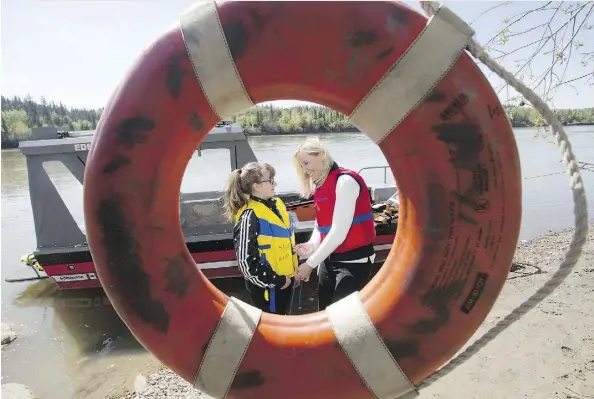  ?? DAVID BLOOM ?? Quinn Carter, 11, and Edmonton aquatic program co-ordinator Debi Curry demonstrat­e the correct way to put on a life-jacket during a National Life-jacket Day event in Sir Wilfrid Laurier Park on Thursday. Canada has the most deaths due to drowning...