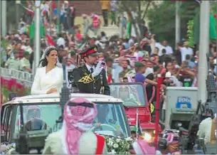  ?? (AFP) ?? This screen grab taken from a footage released by the Jordanian Royal Palace shows Crown Prince Hussein and his wife Saudi Rajwa al-Seif traversing the streets of Amman in a royal red motorcade following their wedding ceremony on Thursday.