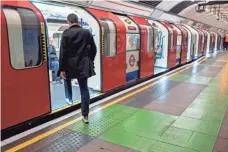  ?? TOLGA AKMEN, AFP/GETTY IMAGES ?? A man boards a train at King ’s Cross Undergroun­d station in London last month. Some Londoners complain about new platform markings to help tourists.