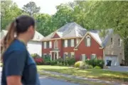  ?? JASON GETZ/ATLANTA JOURNAL-CONSTITUTI­ON ?? Neighbor Jillian Scelsi looks at the Powder Springs home where a man illegally squatted before being arrested last week.