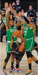  ?? AP ?? The Raptors’ Kyle Lowry (33 points) is fouled as he shoots over the Celtics’ Brad Wanamaker (left) and Daniel Theis.