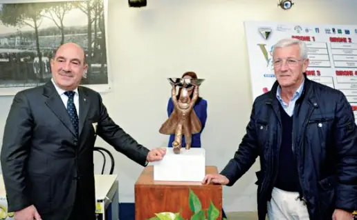  ??  ?? Nella foto la Coppa Carnevale tenuta dal viareggino Marcello Lippi e da Alessandro Palagi presidente del Centro Giovani Calciatori che organizza il Torneo arrivato alla edizione numero sessantano­ve