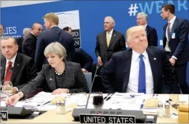  ?? THE ASSOCIATED PRESS ?? President Donald Trump, right, reacts as he sits next to Britain’s Prime Minister Theresa May, center, and Turkish President Recep Tayyip Erdogan as they participat­e in a working dinner meeting during the NATO summit of heads of state and government at...