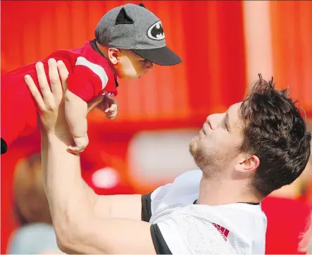  ?? DARREN MAKOWICHUK ?? Calgary Stampeders’ Rob Cote with his new son Wynn after training camp at McMahon Stadium in May.