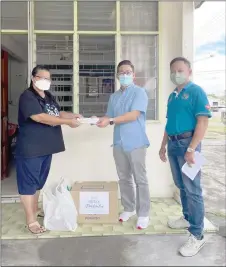  ?? ?? Tiang (centre) hands over his contributi­on to Lim’s widow Huang Ung Kiong while Socso Sibu branch manager Tan Phang Chia (right) looks on.