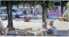  ??  ?? De la terrasse de l’Absinthe, un touriste anglais prend la basilique en photo à travers les arbres.