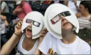  ?? ASSOCIATED PRESS ?? Annie Gray Penuel and Lauren Peck, both of Dallas, wear their makeshift eclipse glasses at Nashville’s eclipse viewing party ahead of the solar eclipse at First Tennessee Park on Monday in Nashville, Tenn.