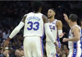  ?? MICHAEL PEREZ — THE ASSOCIATED PRESS ?? Sixers guard Ben Simmons, center, celebrates with T.J. McConnell, right, and Robert Covington during the first half of Saturday’s game against Orlando. Simmons would exit soon after with back tightness, but coach Brett Brown wasn’t overly concerned following a 116-115 win.