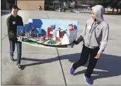  ??  ?? Erickson Ng, 13, left, and Daniel Gao, 13, from
A. P. Giannini Middle School in San Francisco, carry their project in for judging during the Future City’s Northern California regional competitio­n at Monroe Middle School in San Jose on Saturday.