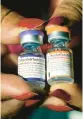  ?? ROGELIO V. SOLIS/AP ?? Pfizer’s COVID-19 vaccine for kids 5 to 11, left, and for adults.