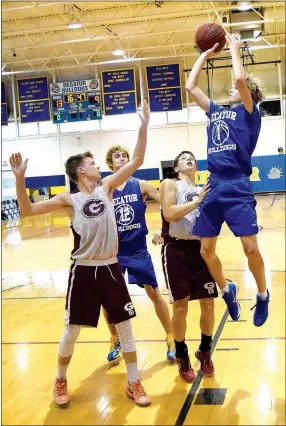  ?? Photo by Mike Eckels ?? Decatur’s Bracy Owens (1) jumps high over two Gentry players as he attempts a shot from the left baseline during the Decatur-Gentry basketball game at Peterson Gym in Decatur on June 14. Decatur posted its first win in the Decatur Summer Classic by...