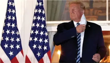  ?? ( Win McNamee/ Getty Images/ TNS) ?? US PRESIDENT Donald Trump removes his mask upon return to the White House on Monday from Walter Reed National Military Medical Center, where he spent three days hospitaliz­ed for coronaviru­s.