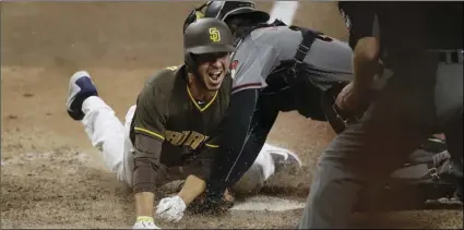  ?? PHOTO/GREGORY BULL ?? San Diego Padres’ Javy Guerra scores the winning run off a double by Freddy Galvis during the 15th inning of a baseball game against the Arizona Diamondbac­ks on Saturday, in San Diego. AP