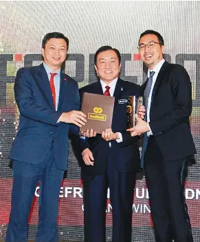  ??  ?? Yap presenting the Platinum award for Malaysian Business of the Year to Forefront Studio Sdn Bhd chief executive officer, Darien Mah while Internatio­nal Trade and Industry Minister II, Datuk Seri Ong Ka Chuan looks on.