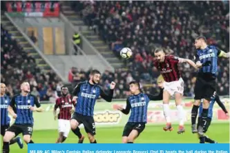  ??  ?? MILAN: AC Milan’s Captain Italian defender Leonardo Bonucci (2nd R) heads the ball during the Italian Serie A football match AC Milan vs Inter Milan at the San Siro stadium in Milan yesterday. — AFP