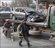  ?? RAHMAT GUL / ASSOCIATED PRESS ?? Afghan security forces remove a destroyed vehicle after a suicide attack Monday outside the Afghan national intelligen­ce agency headquarte­rs near the presidenti­al palace in Kabul, Afghanista­n.