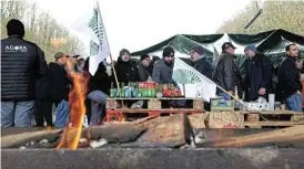  ?? /Reuters ?? No further: French farmers block the A16 highway near Beauvais on Thursday to protest over price pressures, taxes and green regulation — grievances shared by farmers across Europe.